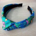 Tocado o diadema infantil con diseño de personajes Disney Stitch y campanitas en colores vivos y tela suave.