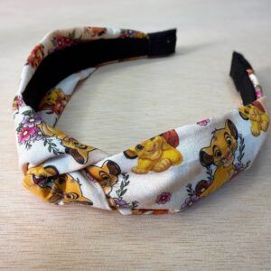 Diadema con estampado de Simba y personajes de El Rey León, ideal para acompañar outfits infantiles y temáticas de Disney.