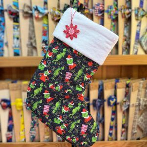 Uds. de calcetín navideños con motivos de Grinch y felpa blanca en la parte superior.